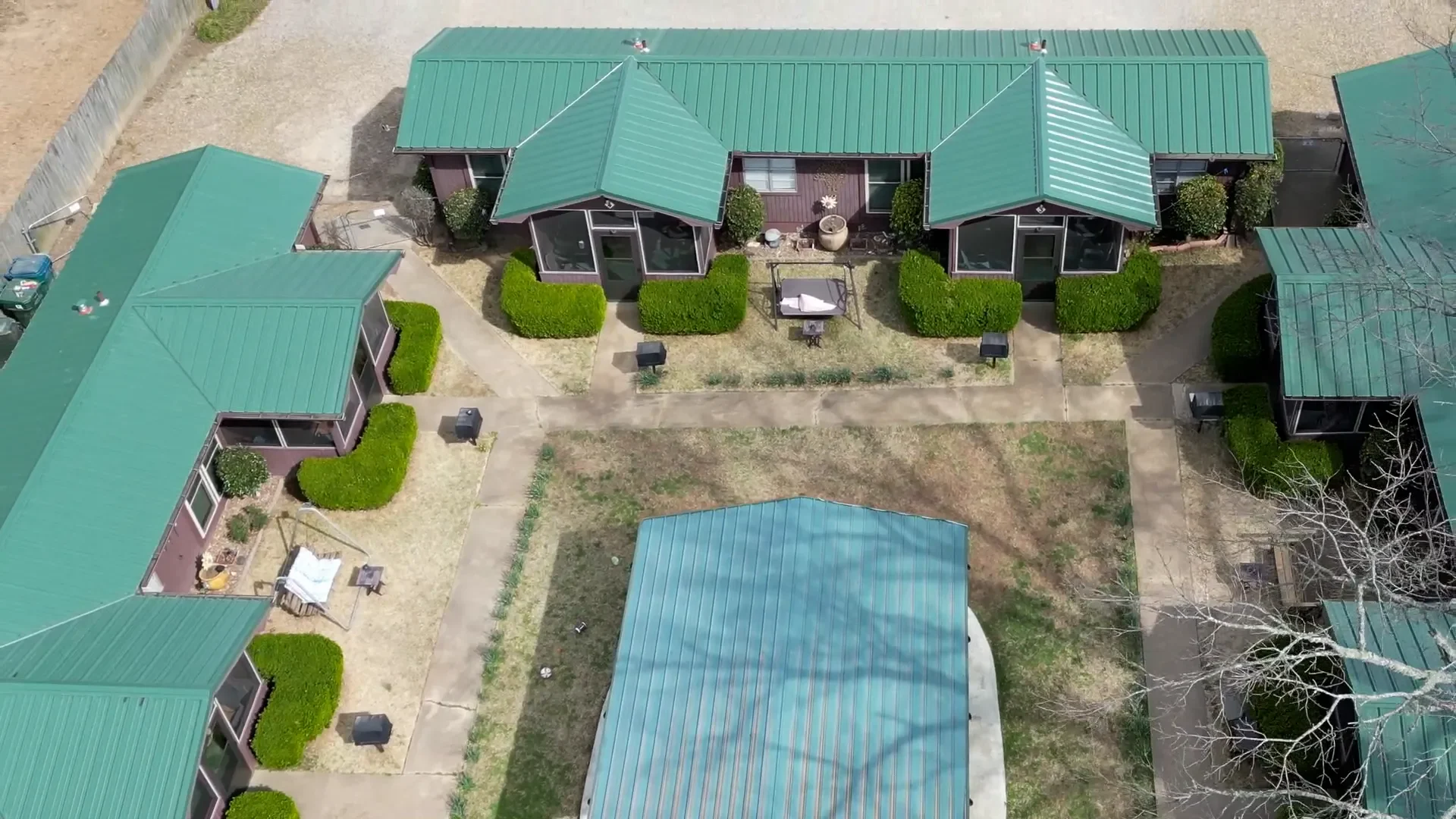 Green standing-seam metal roofs installed across a multi-unit commercial property